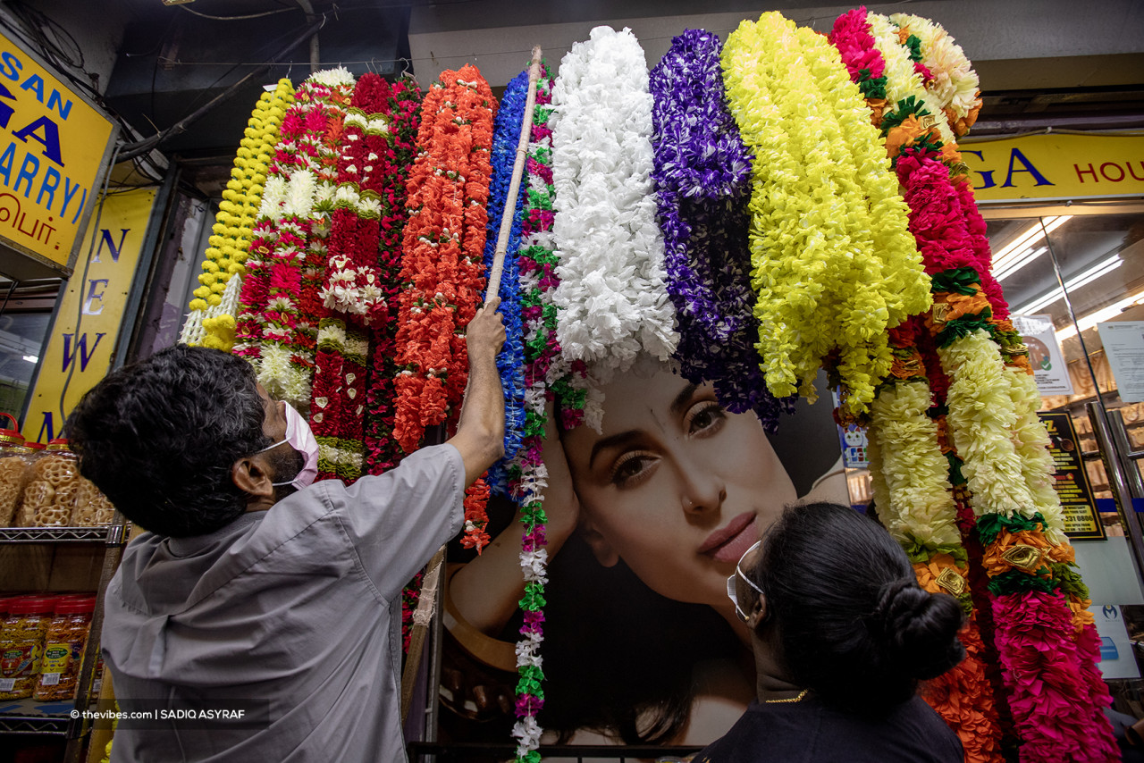 A shopkeeper arranging flower garlands up for sale. These eye-catching decorations are a must-have for any Hindu celebration. – SADIQ ASYRAF/The Vibes pic, November 4, 2021