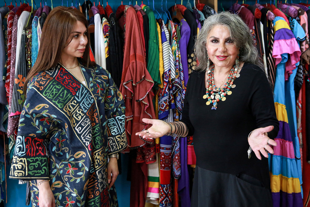 Franco-Iraqi fashion designer residing in Jordan Hana Sadiq speaks of one of her designs incorporating Arabic calligraphy in the "Thuluth" script. – AFP pic