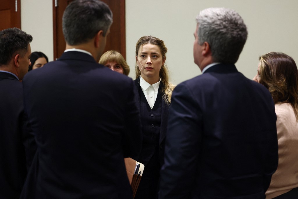 Heard with her legal team after court recessed for the day during the trial on April 21. – AFP pic