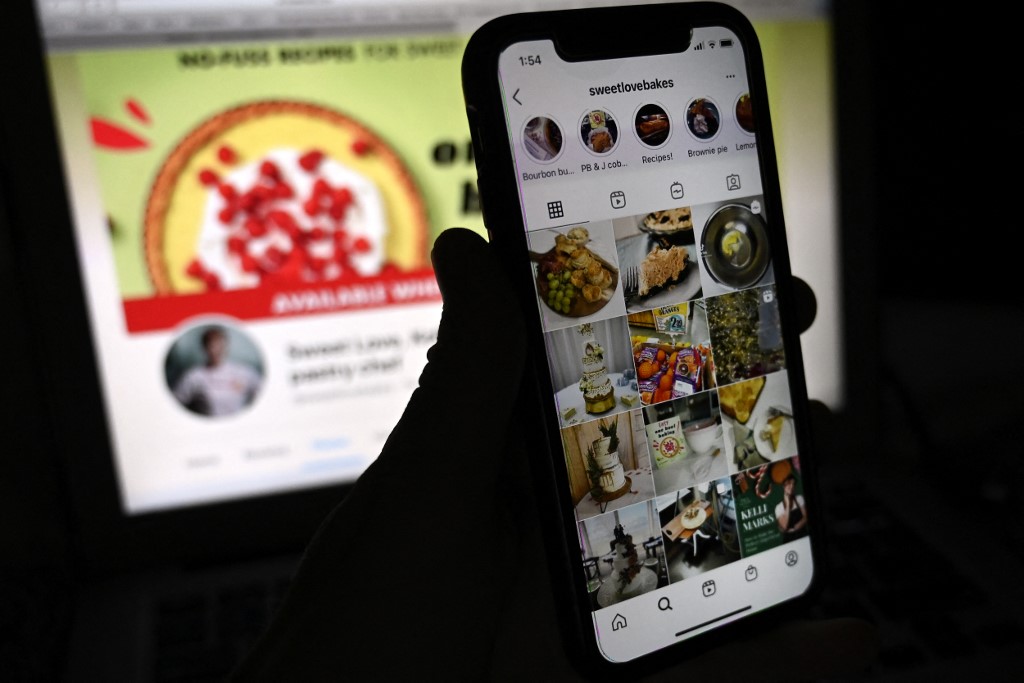 In this photo illustration, the Instagram account of Pastry Chef Kelli Marks is displayed on a mobile phone with Marks's Facebook page shown in the background. – AFP pic