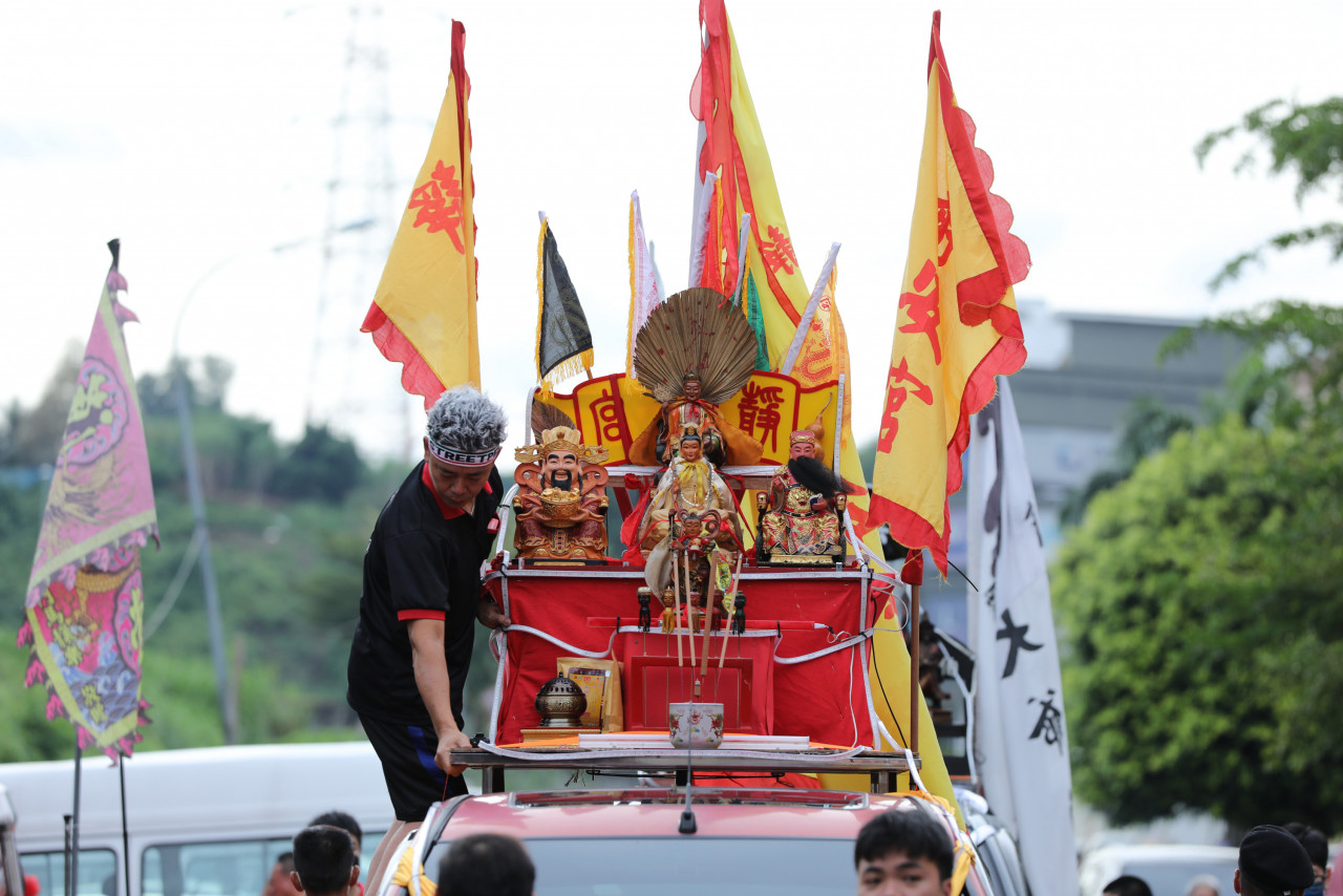 A devotee adjusts the deities placed on a truck before the beginning of the procession. – Pic by Alif Omar