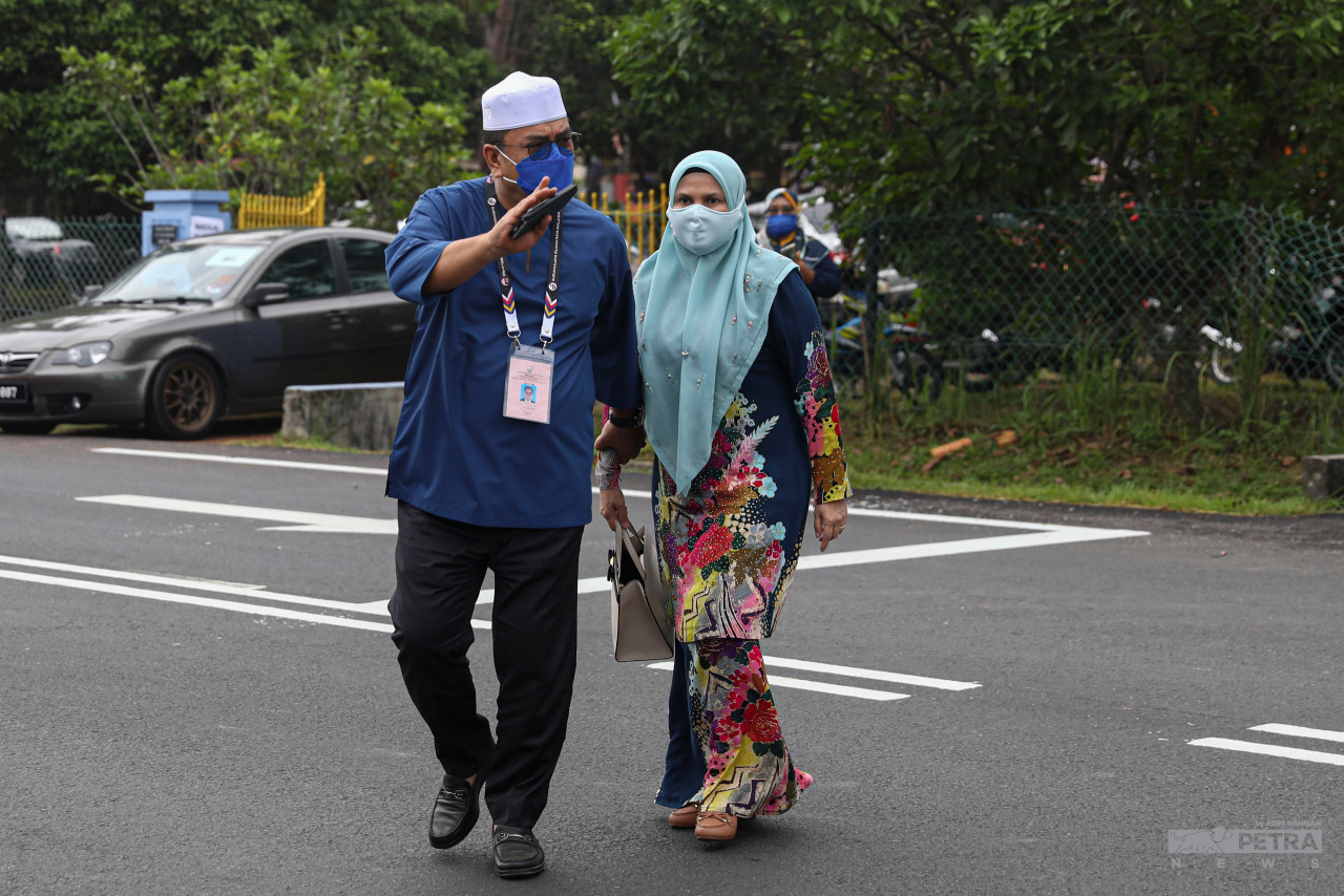 Barisan Nasional’s chief minister candidate Datuk Seri Sulaiman Md Ali (left) and his wife out to cast their votes at SK Durian Daun (K) Masjid Tanah for the Lendu constituency. – AZIM RAHMAN/The Vibes pic, November 20, 2021