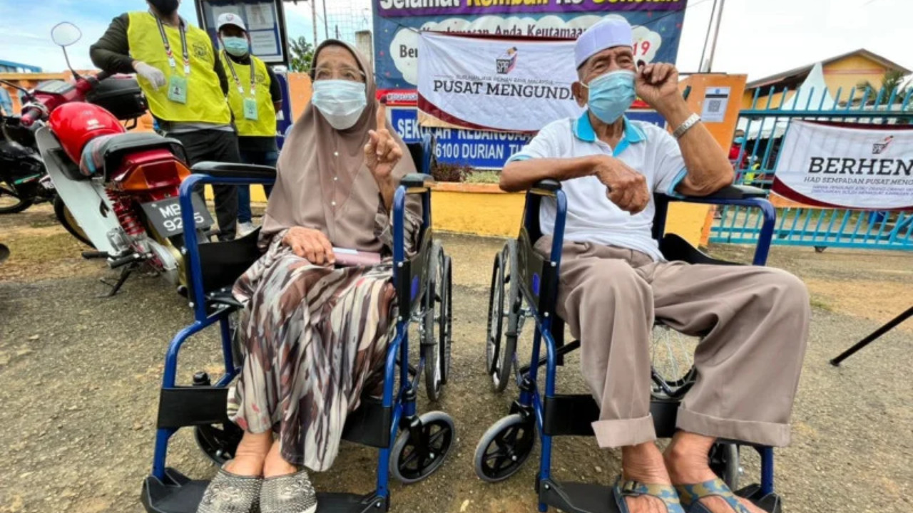 Che Ta Md Som, 89, and her 90-year-old husband Fajar Hasan (right) have not wasted the opportunity to exercise their democratic right in Melaka today, saying they do not fear Covid-19 as they are fully vaccinated. – ARJUN MOHANAKRISHNAN/The Vibes pic, November 20, 2021