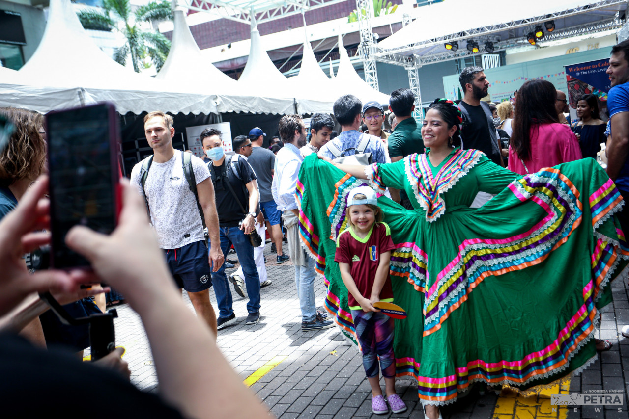 A boy has a picture taken with one of the models at the festival. – The Vibes pic/Nooreeza Hashim
