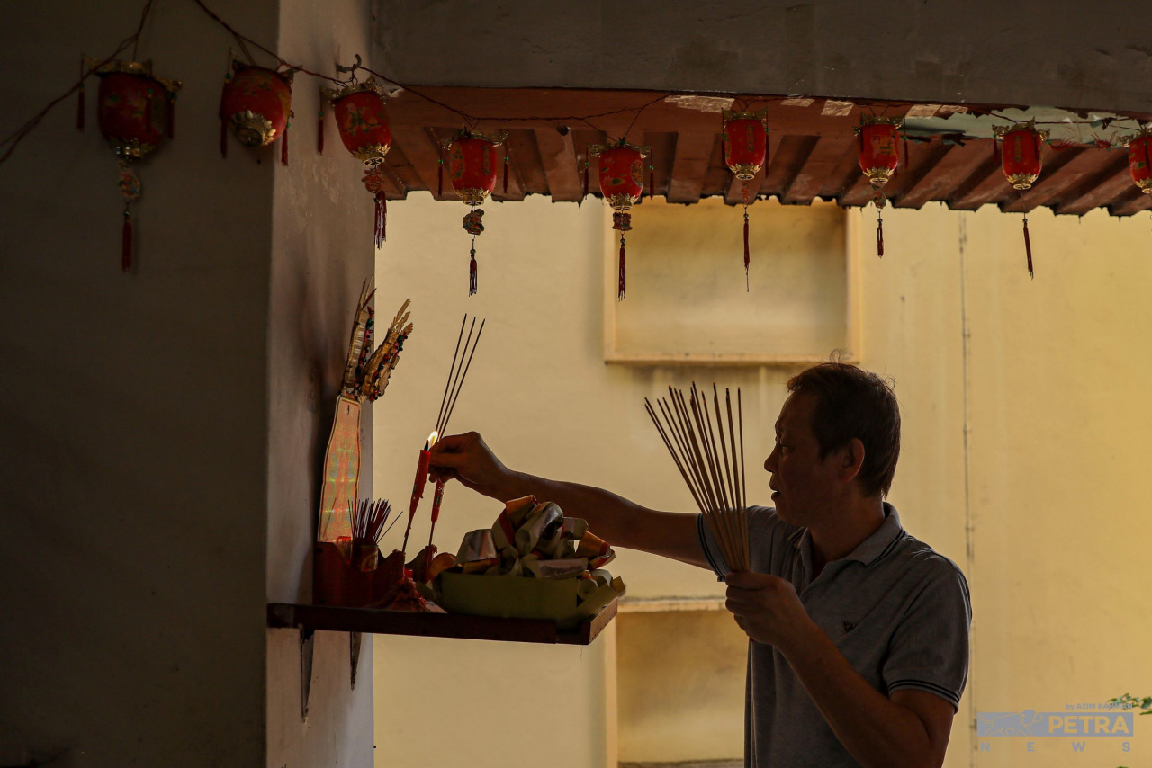 Swee Huat holding joss sticks for morning prayers at the altar outside his flat unit. — The Vibes/Azim Rahman pic