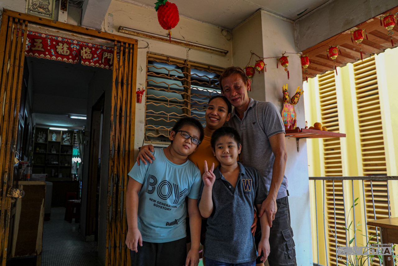 The Soh family, in front of their flat unit in Blue Boy Mansion. — The Vibes/Azim Rahman pic