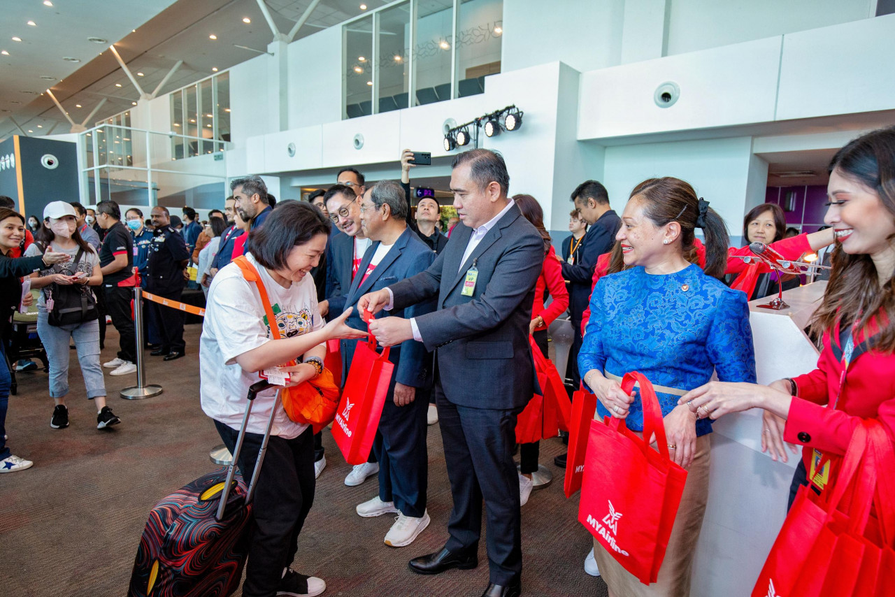 Anthony Loke distributes goodies to passengers of flight Z9550. – Pic courtesy of MYAirline