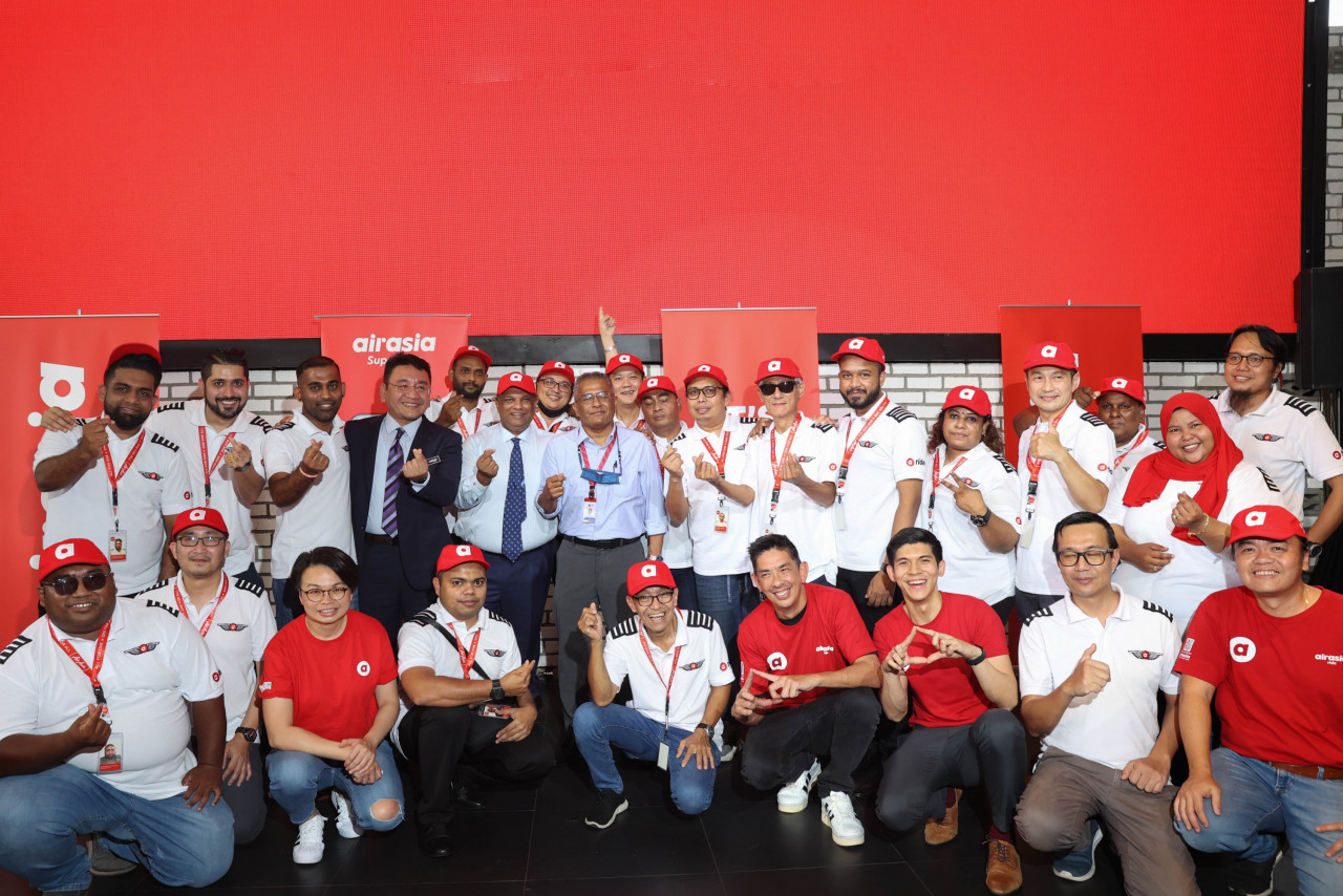 Perkeso representative, Azirruan, Capital A CEO Tony Fernandes, KWSP representative Shamsul Kamar, AirAsia Super App CEO Amanda Woo, Capital A President (Commercial) Colin Currie, AirAsia Super App Head of Delivery (Group) Lim Ben-Jie, and Air Asia regional CEO Lim Chiew Shan pose with full-time AirAsia Ride drivers. – Pic courtesy of AirAsia Communications