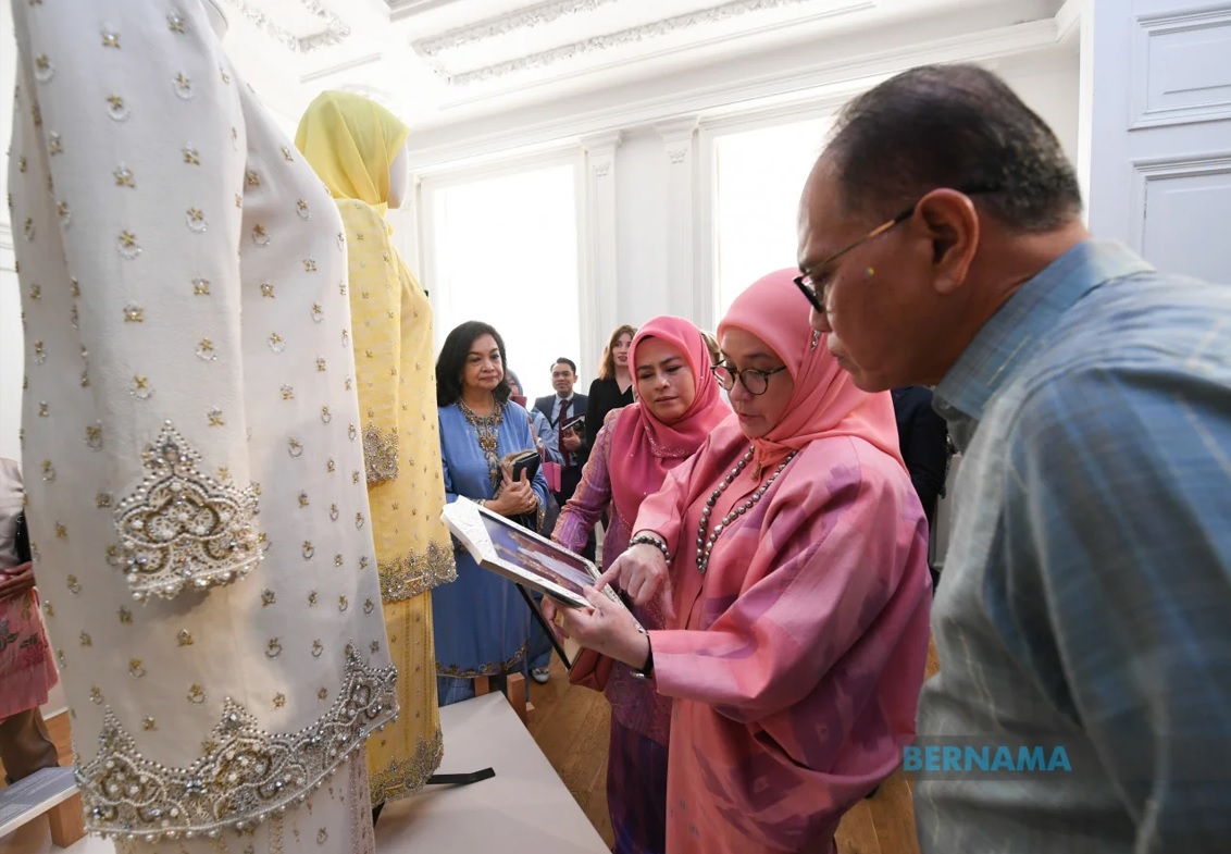 Pahang Mentri Besar Datuk Seri Wan Rosdy Wan Ismail looks and listens as the queen describes some of her own garments. – Bernama pic