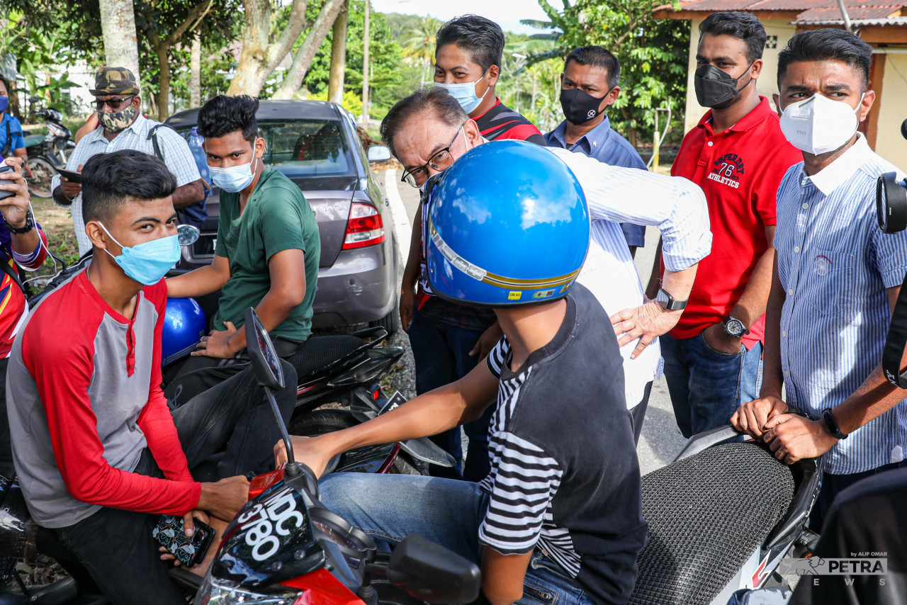 Datuk Seri Anwar Ibrahim having a friendly chat with youth while helping Pakatan Harapan candidates campaign in the Rim constituency. – ALIF OMAR/The Vibes pic, November 19, 2021