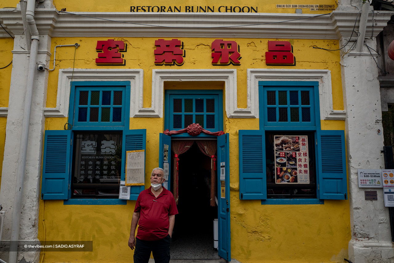 A man standing in front of the Bunn Choon Restaurant, the place to get one of the best egg tarts in KL, thanks to its traditional recipe passed down since it opened in 1893. – Sadiq Asyraf/The Vibes pic