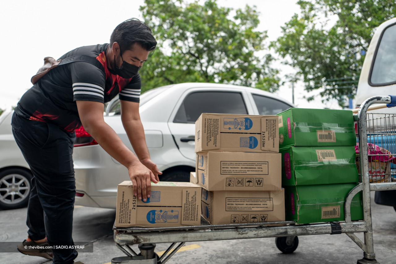 A customer preparing for the water supply disruption with boxes of bottled water. – SADIQ ASYRAF/The Vibes pic, October 12, 2021