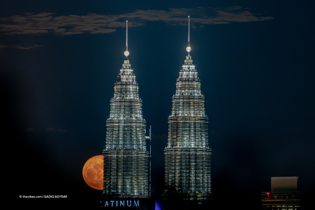 A full moon peeping out from behind the Petronas Twin Towers shortly after dusk. – SADIQ ASYRAF/The Vibes pic, October 8, 2021