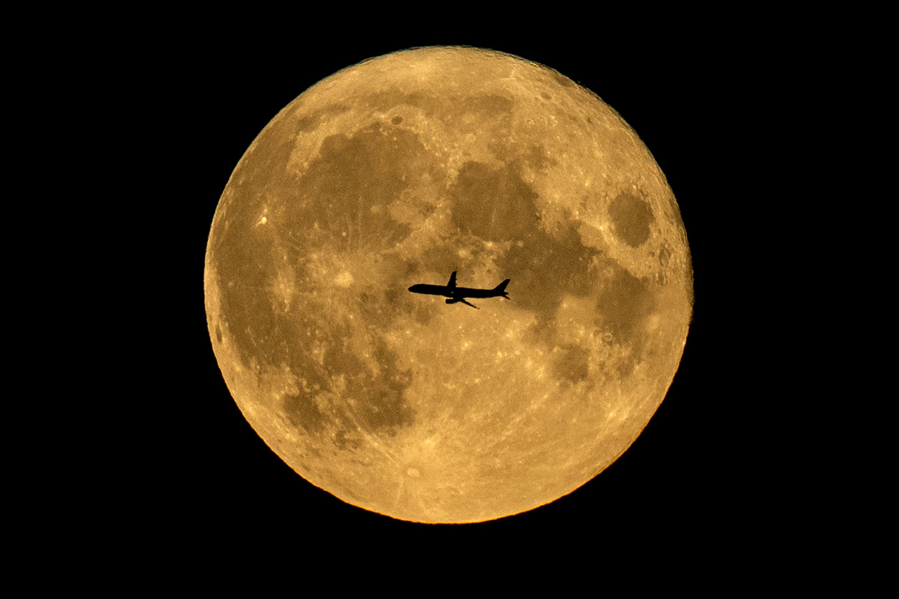 A plane silhouetted against a full moon in Moscow. – KIRILL KUDRYAVTSEV/AFP pic, October 8, 2021