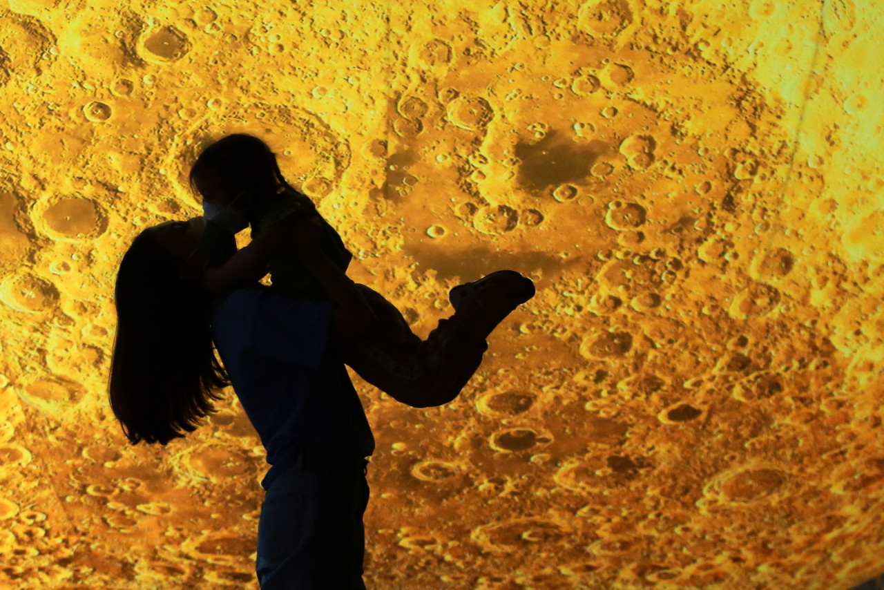 A woman holding a child in front of a moon installation during the Mid-Autumn Festival celebration in Yangzhou in China’s eastern Jiangsu province. – AFP pic, October 8, 2021