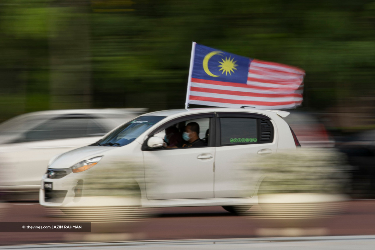 Drivers usually fly a smaller version of Jalur Gemilang on their cars, but this motorist sports a full-sized flag on his in spirit of the celebration. – AZIM RAHMAN/The Vibes pic, September 16, 2021