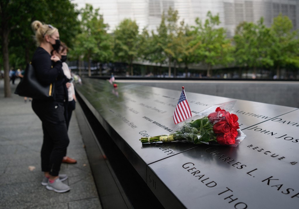 A couple stands before the National September 11 Memorial, marking the site of the south tower at the World Trade Center in New York, on September 8, 2021. – AFP pic