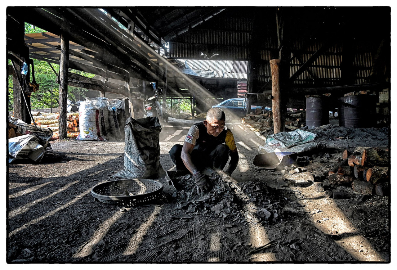 A man toils at a charcoal factory in Kuala Sepetang. – Pic courtesy of Philippe Durant