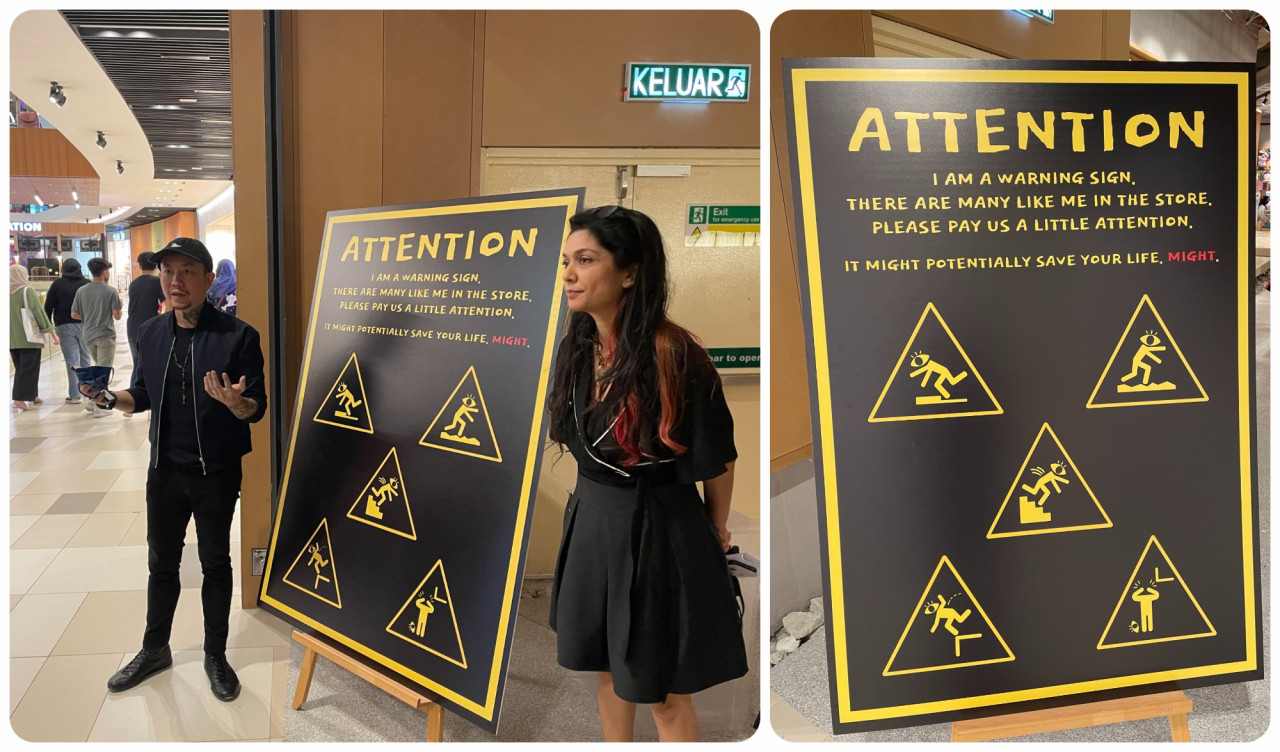 (L) Andrew Yap, founder of BookXcess, and (R) Geetha Nair, head of PR, give a briefing on the store next to a comedic tinged warning sign. – Haikal Fernandez pic