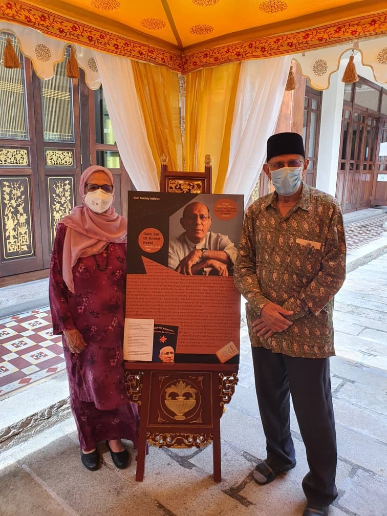 Datin Seri Mahmuda and Datuk Seri Dr Anwar Fazal pose in front of an exhibit celebrating the latter's achievements. – Pic courtesy of Penang Heritage Trust