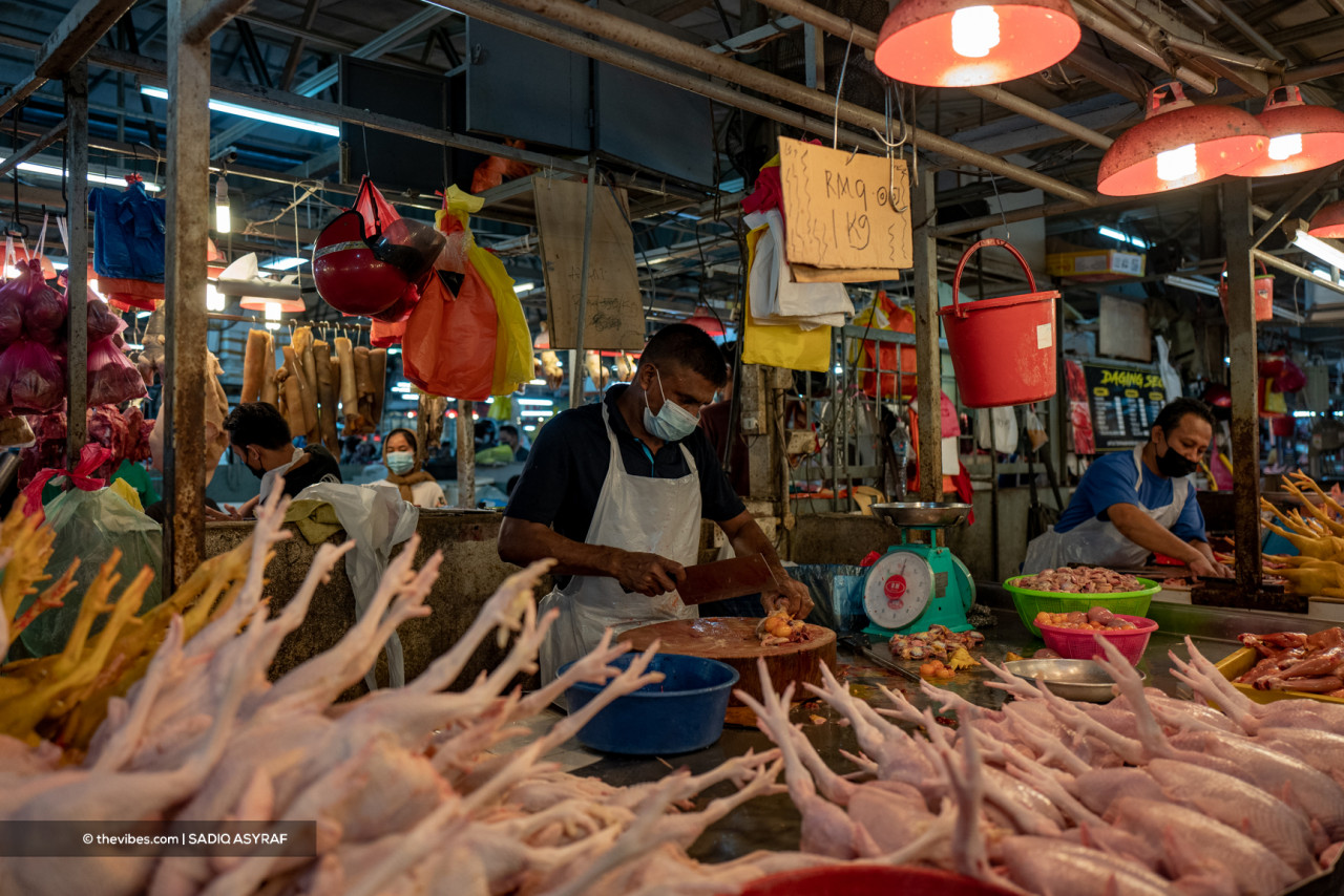 A butcher in his element as he chops up meat surrounded by chicken feet. – SADIQ ASYRAF/The Vibes pic, October 2, 2021