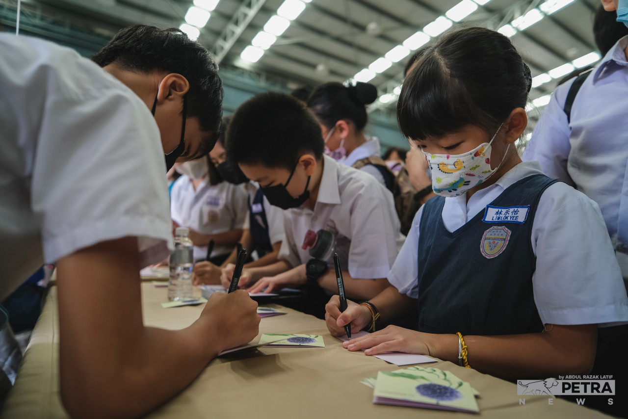 Pupils of SJK(C) Mun Choong pen messages to the landslide victims, which included some of their own teachers. – ABDUL RAZAK LATIF/The Vibes pic, December 31, 2022