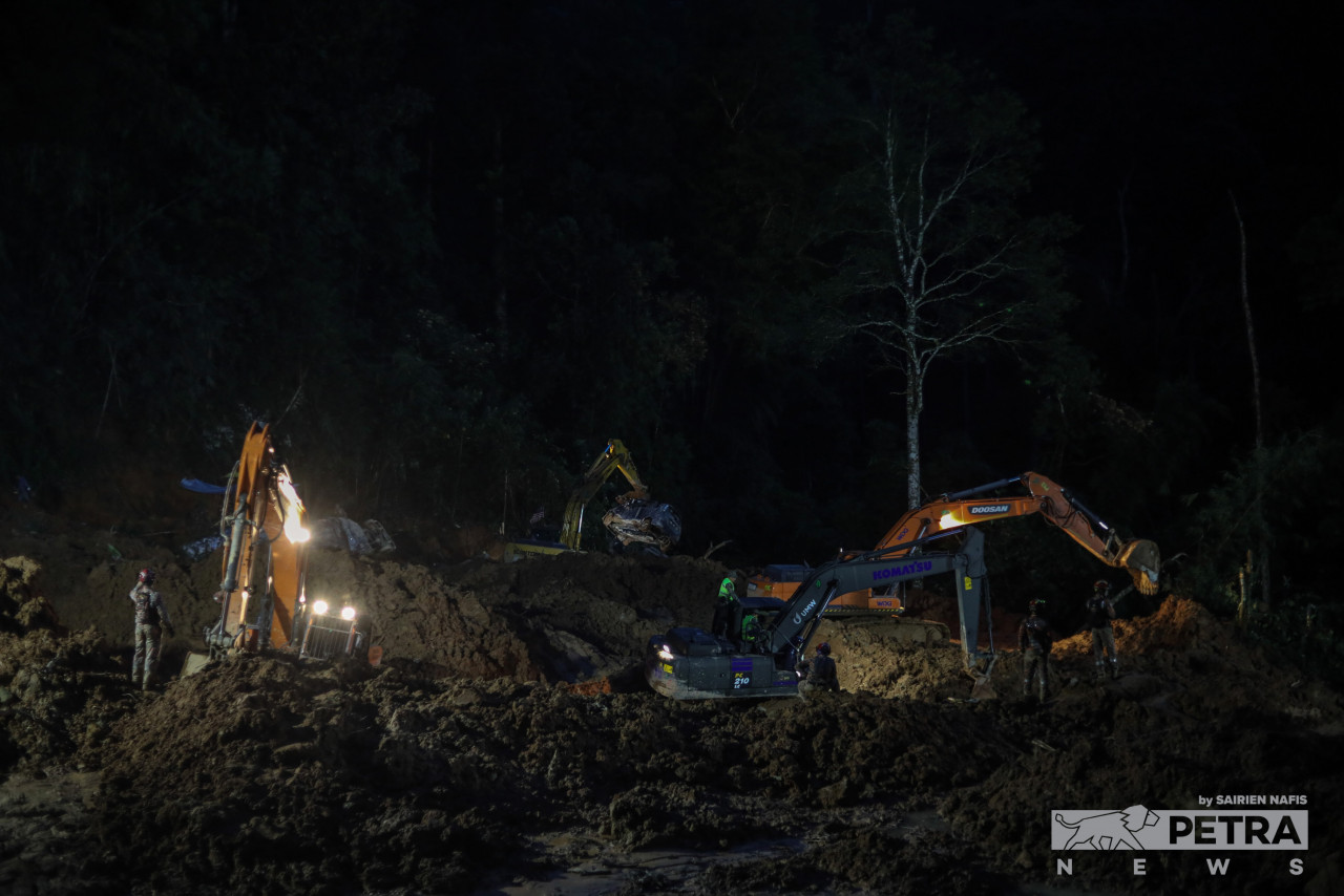 Rescuers with excavators at work late at night yesterday in their search for victims of the Batang Kali landslide. – SAIRIEN NAFIS/The Vibes pic, December 21, 2022