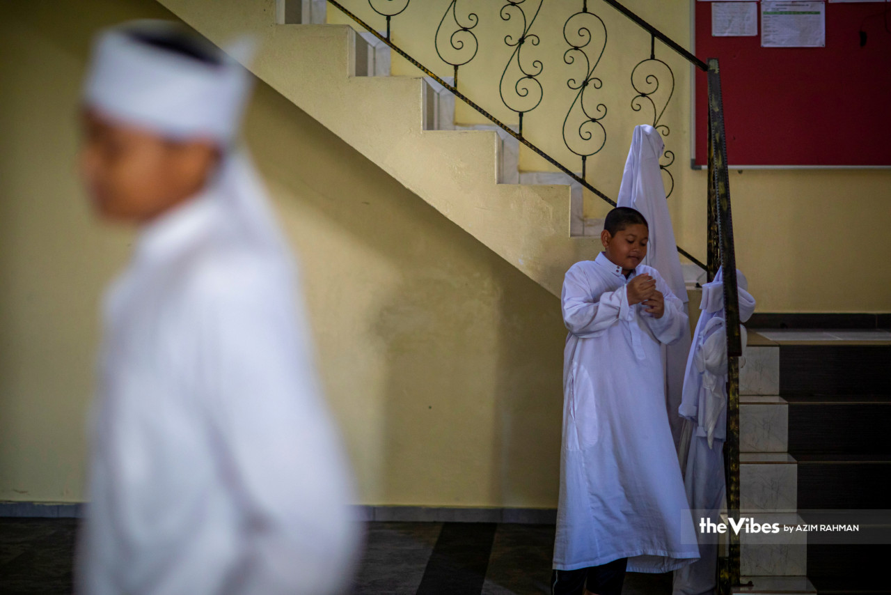 Tahfiz students put on their jubah before commencing Quran-reading lessons. – AZIM RAHMAN/The Vibes pic, April 9, 2023