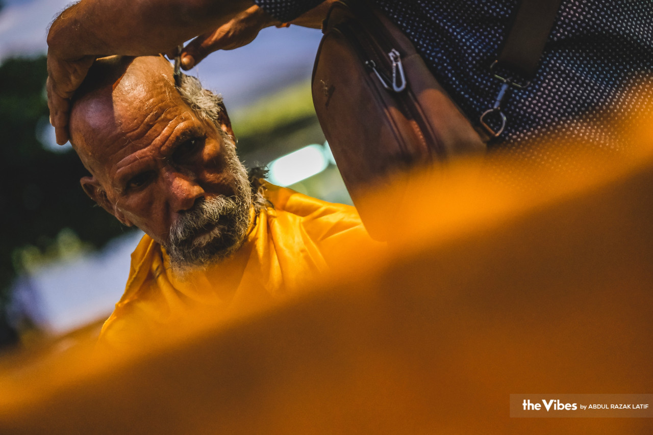 Looking contemplative, a devotee gets his head shaved as preparation for Thaipusam rituals. – ABDUL RAZAK LATIF/The Vibes pic, February 6, 2023