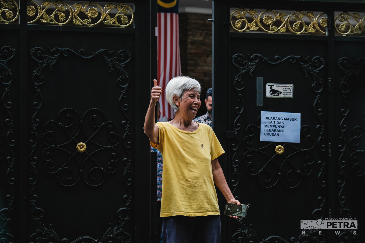A jubilant woman stands outside the gate of Datuk Seri Anwar Ibrahim’s office at Bukit Gasing in Petaling Jaya, Selangor on Thursday. Anwar’s supporters had gathered in droves outside both his office and at his residence in Sg Long, Kajang following the announcement that he would be the nation’s 10th prime minister. – ABDUL RAZAK LATIF/The Vibes pic, November 26, 2022