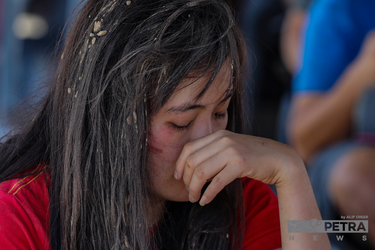 A victim of the landslide gathers her composure at the Hulu Yam Bharu police station. – ALIF OMAR/The Vibes pic, December 16, 2022