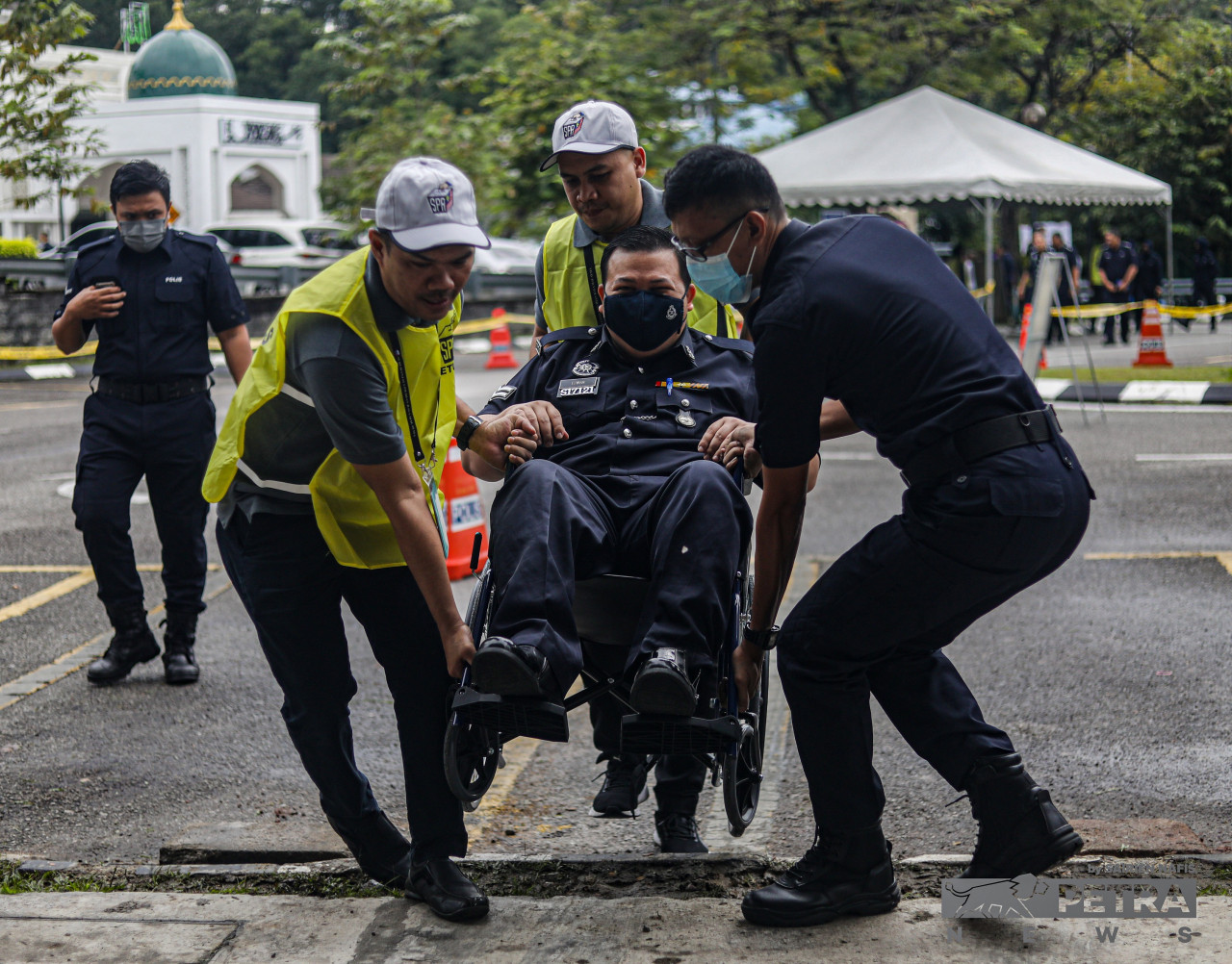 Polling officers and colleague helps Royal Malaysian Police Corporal Mohd Ezwan Mohammed @ Yusuf who, despite being in a wheelchair, happily arrives to cast his early ballot at the Selangor Contingent Police Headquarters today. – SAIRIEN NAFIS/The Vibes pic, November 15, 2022