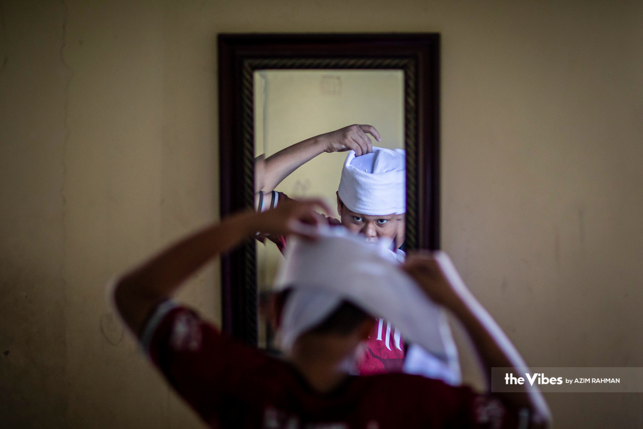 A tahfiz student wraps his serban before beginning a day of Quran recitations. – AZIM RAHMAN/The Vibes pic, April 9, 2023 