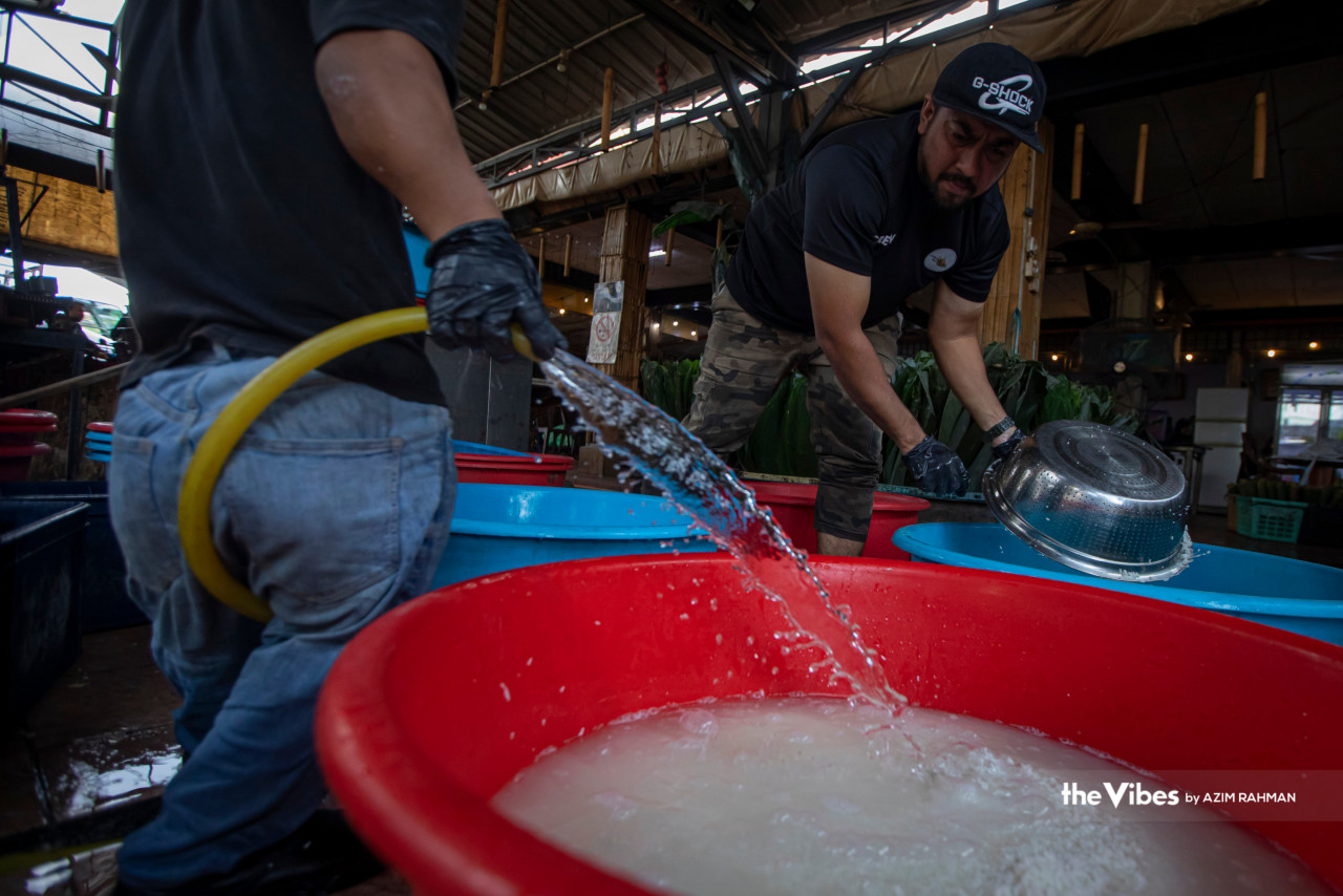 Lemang Daun Lerek Greenwood workers wash the glutinous rice before mixing it with santan. – AZIM RAHMAN/The Vibes pic, April 17, 2023