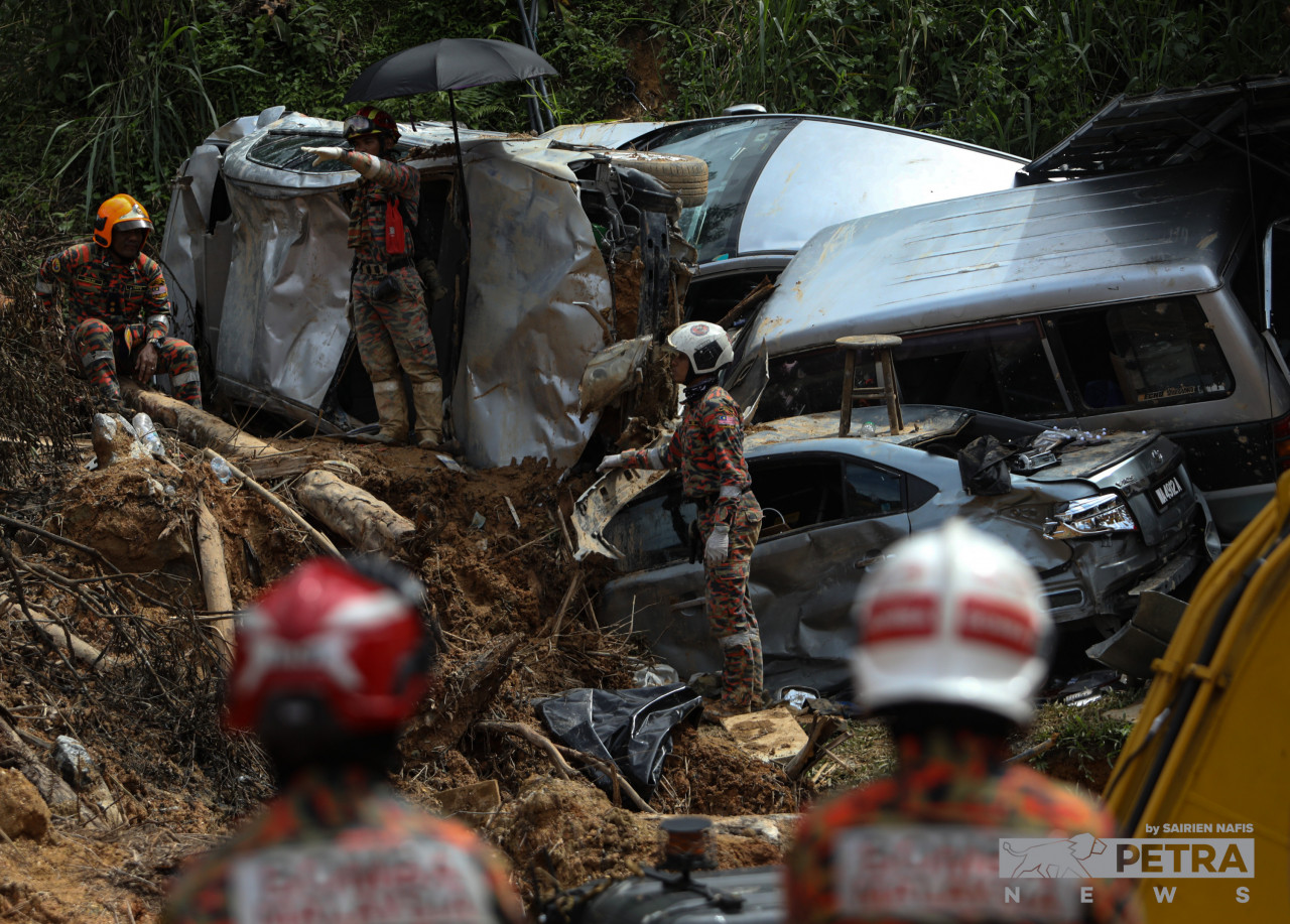 Rescue workers comb through cars wrecked by the landslide at a campsite situated in Father’s Organic Farm at Batang Kali. – SAIRIEN NAFIS/The Vibes pic, December 25, 2022