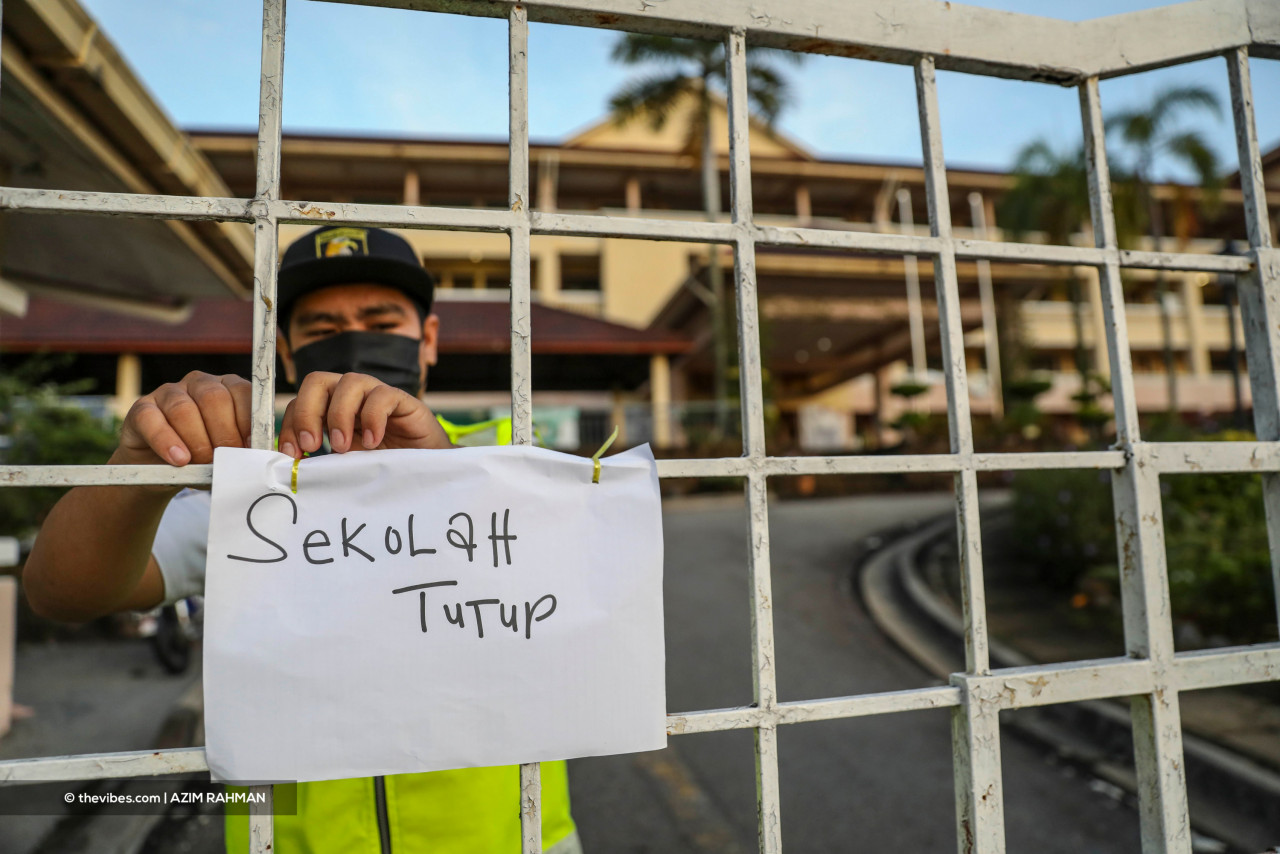A security guard stands at the gate of a school with a "school closed" sign during the Covid-19 pandemic last year. Experts say the move could save the government up to hundreds of millions of ringgit each year, an amount deemed essential as the country moves into endemicity following two years of being ravaged by Covid-19. – The Vibes file pic, June 18, 2022