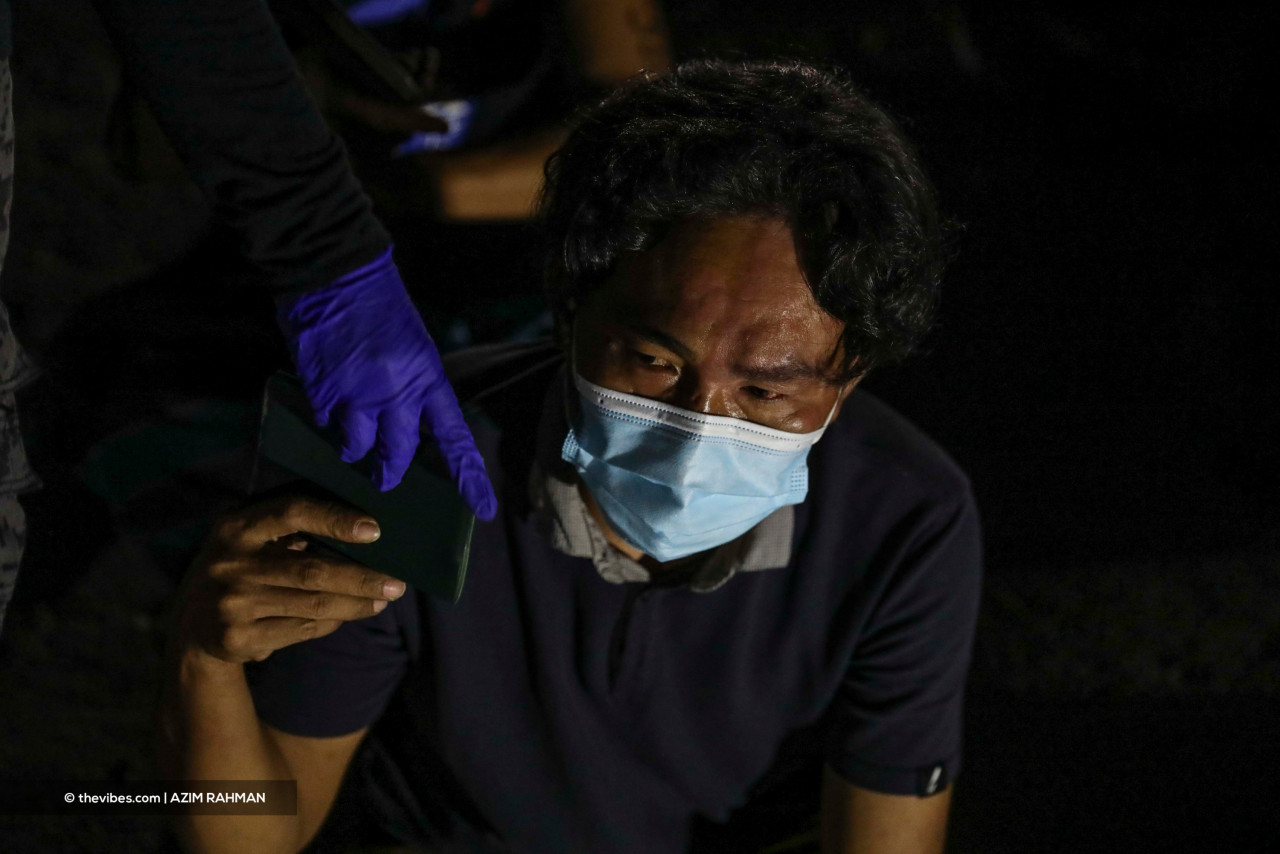 A man handing over his documents to an Immigration officer in the Cyberjaya raid. – AZIM RAHMAN/The Vibes pic, June 7, 2021