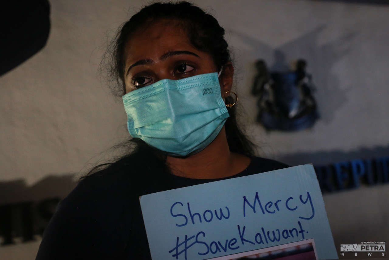A tearful vigil attendee holds up a placard imploring the Singapore government to show mercy to Kalwant Singh. – NOOREEZA HASHIM/The Vibes pic, July 6, 2022