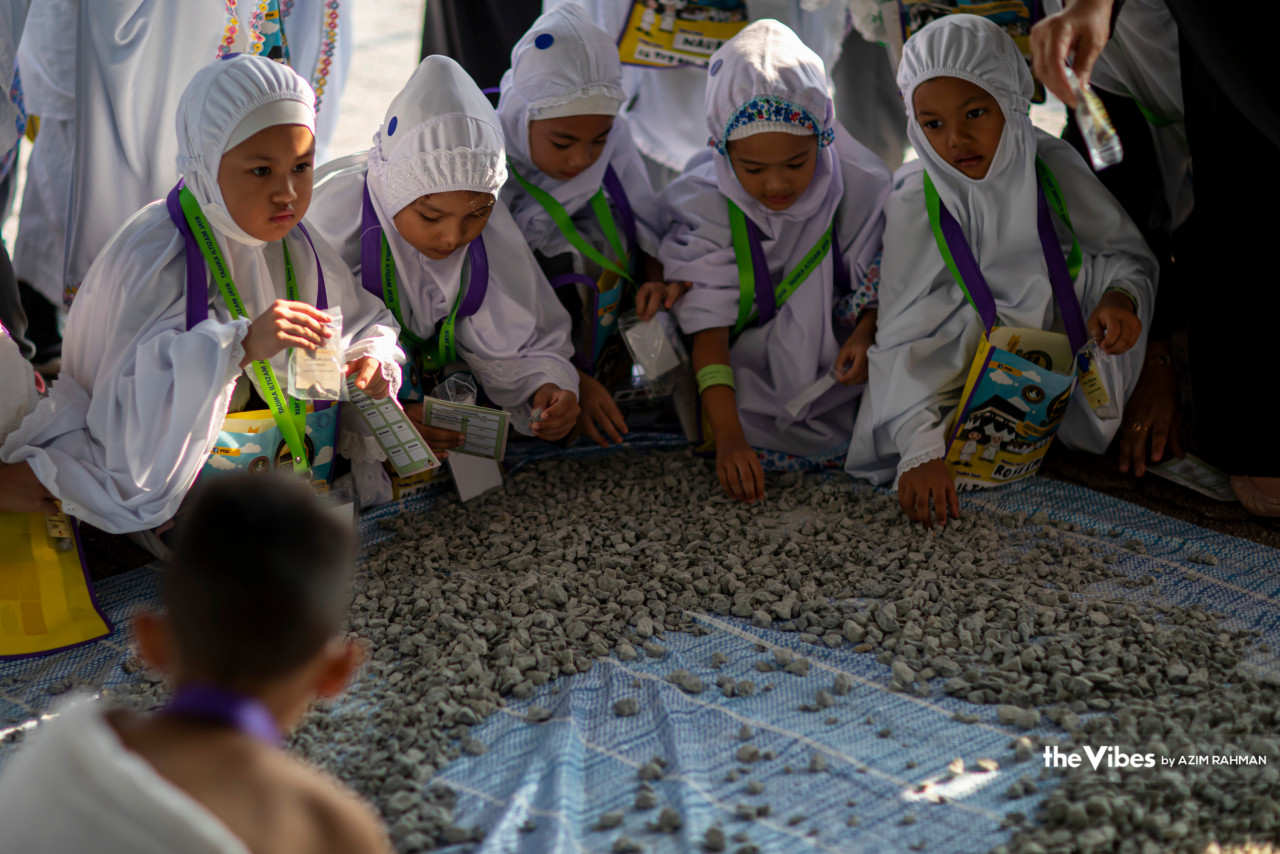 Children learn about the symbolic stoning of the Jamarat. The ritual is a symbolic reenactment of the Prophet Ibrahim’s haj, where he stoned three pillars representing the Shaitan, and Muslims’ temptation to disobey God’s will. – AZIM RAHMAN/The Vibes pic, June 24, 2023