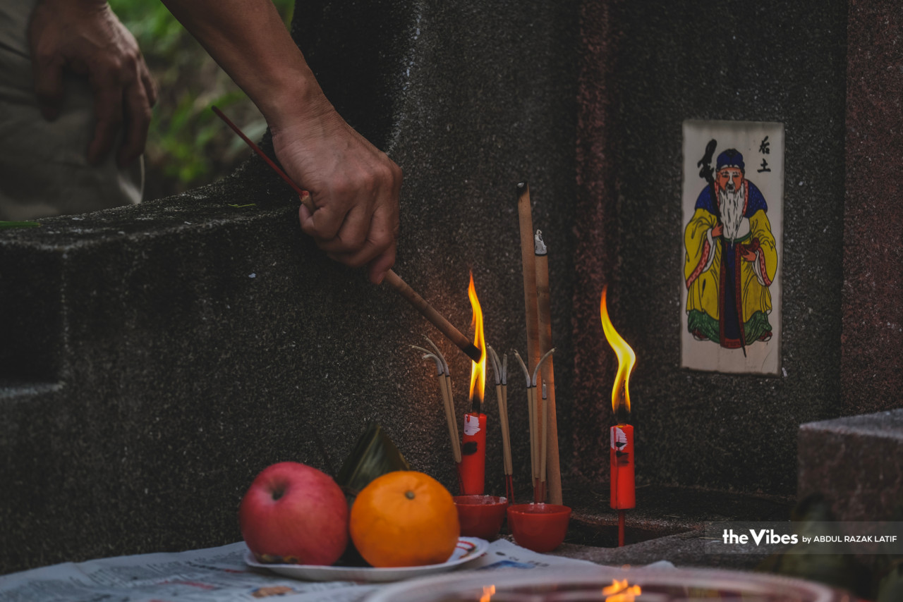 Family members take turns to pay their respects to their ancestors. – ABDUL RAZAK LATIF/The Vibes pic, April 8, 2023