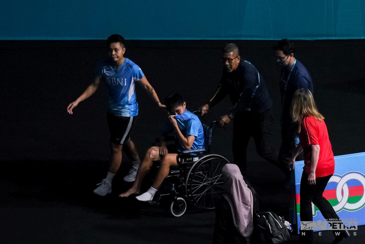 Indonesia’s women’s doubles player Siti Fadia Silva Ramadhanti is wheeled out of the court due to an injury to her left foot and conceded a walkover at the 2023 Malaysia Open semifinal. – ABDUL RAZAK LATIF/The Vibes pic, January 18, 2023