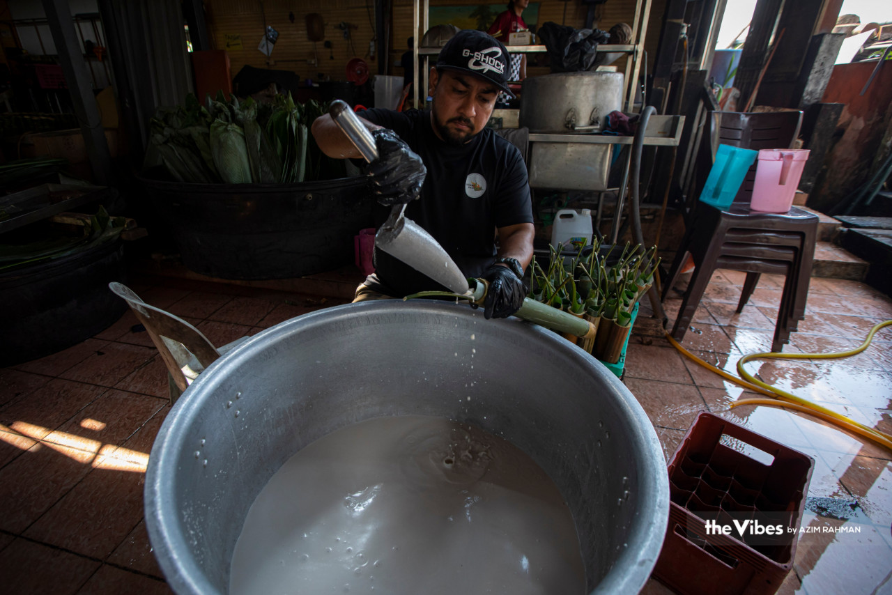 The process of filling in the lemang bamboo with glutinous rice that has been soaked in santan before it is taken to the cooking station. – AZIM RAHMAN/The Vibes pic, April 17, 2023
