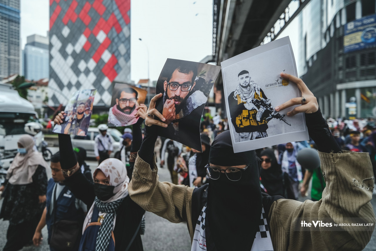 A protestor holds up pictures of Palestinians killed by Israeli forces and who are considered “martyrs”. The photo on the right held up by this female protestor is of Ibrahim al-Nabulsi, described by Middle East media as a senior commander of the Al-Aqsa Martyrs’ Brigades and a wanted person by Israel. He was killed on August 9, 2022. – ABDUL RAZAK LATIF/The Vibes pic, April 15, 2023