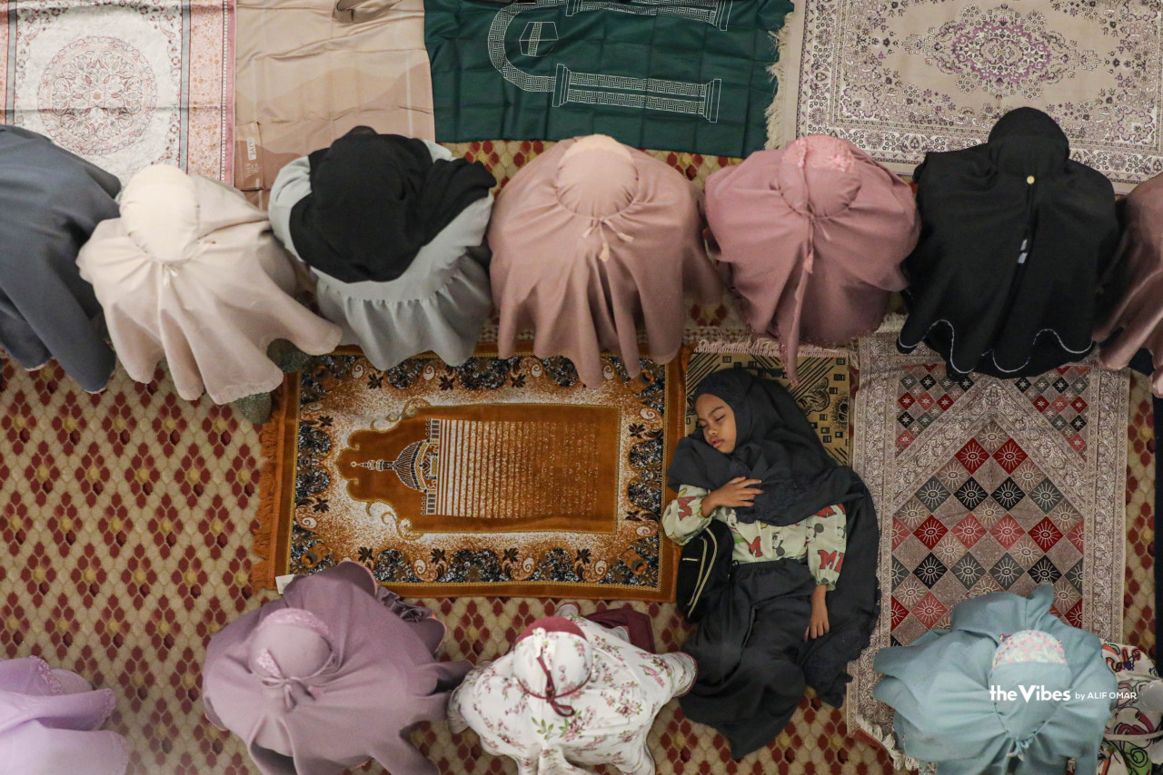 Another child lies down, seemingly sound asleep as women congregants around her perform tarawih prayers at Masjid Negara Kuala Lumpur. – ALIF OMAR/The Vibes pic, March 23, 2023