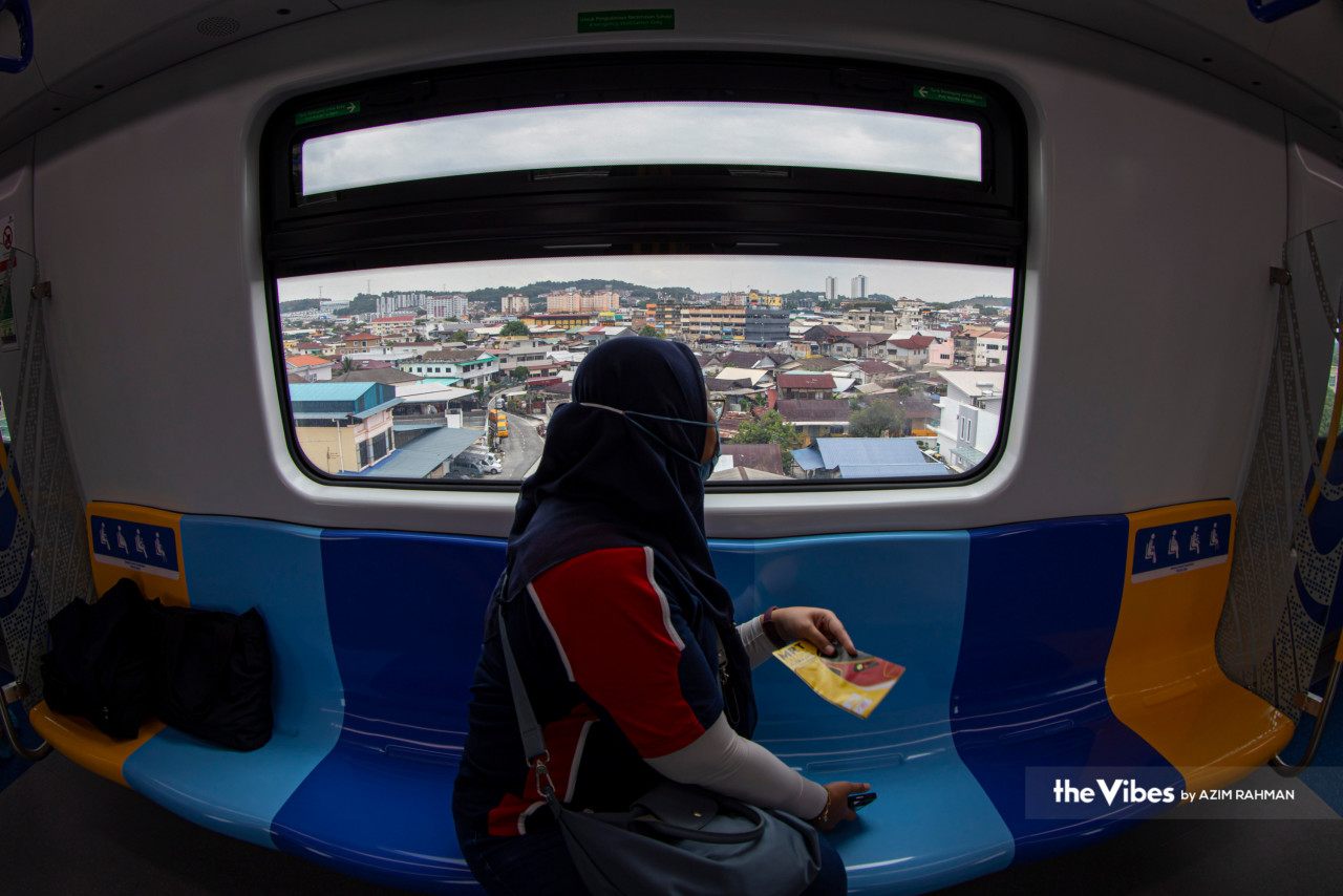 A commuter looks out of the window as the train passes through a neighbourhood on the Putrajaya MRT line. – AZIM RAHMAN/The Vibes pic, March 15, 2023