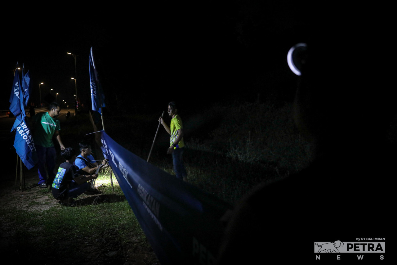 Several Perikatan Nasional supporters from Bera gather late at night to erect flags and banners across stretches of a highway leading to the Kg Kuala Triang. – SYEDA IMRAN/The Vibes pic, November 12, 2022