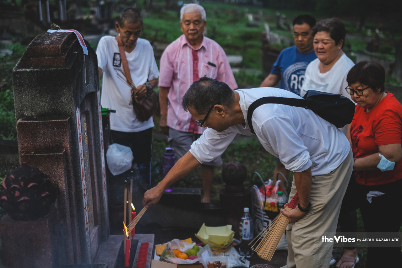 Family members take turns to pay their respects to their ancestors. – ABDUL RAZAK LATIF/The Vibes pic, April 8, 2023
