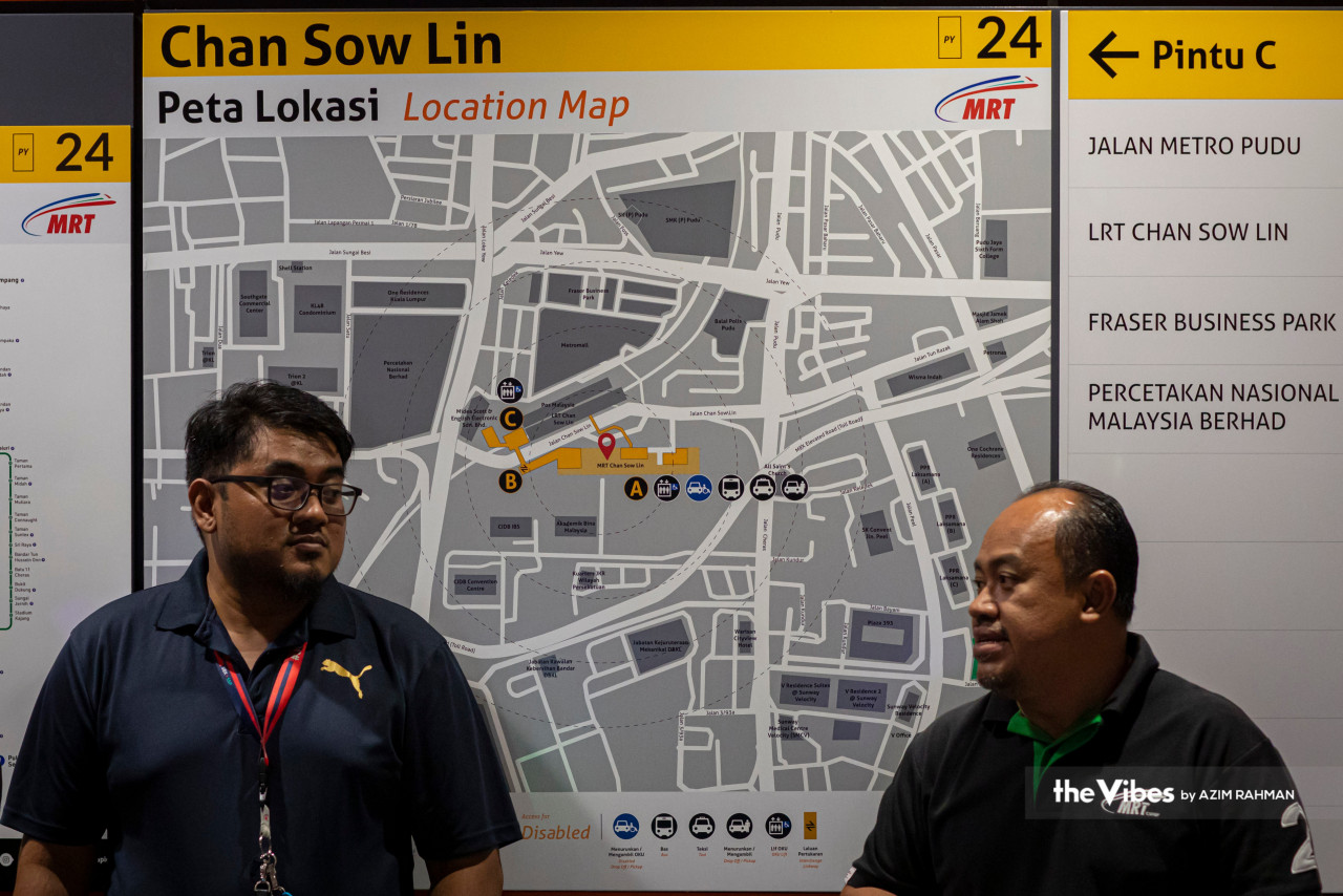 MRT Corp staff stand in front of a location map at the Chan Sow Lin station on the Putrajaya MRT line. – AZIM RAHMAN/The Vibes pic, March 15, 2023