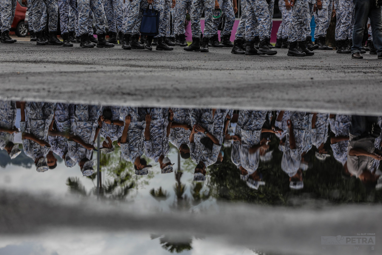 Boots line up despite puddles from the rain filling up holes on the ground as Royal Malaysian Navy members show up to cast their early ballots at SMK Pangkalan TLDM Lumut, Perak polling centre today. – ALIF OMAR/The Vibes pic, November 15, 2022