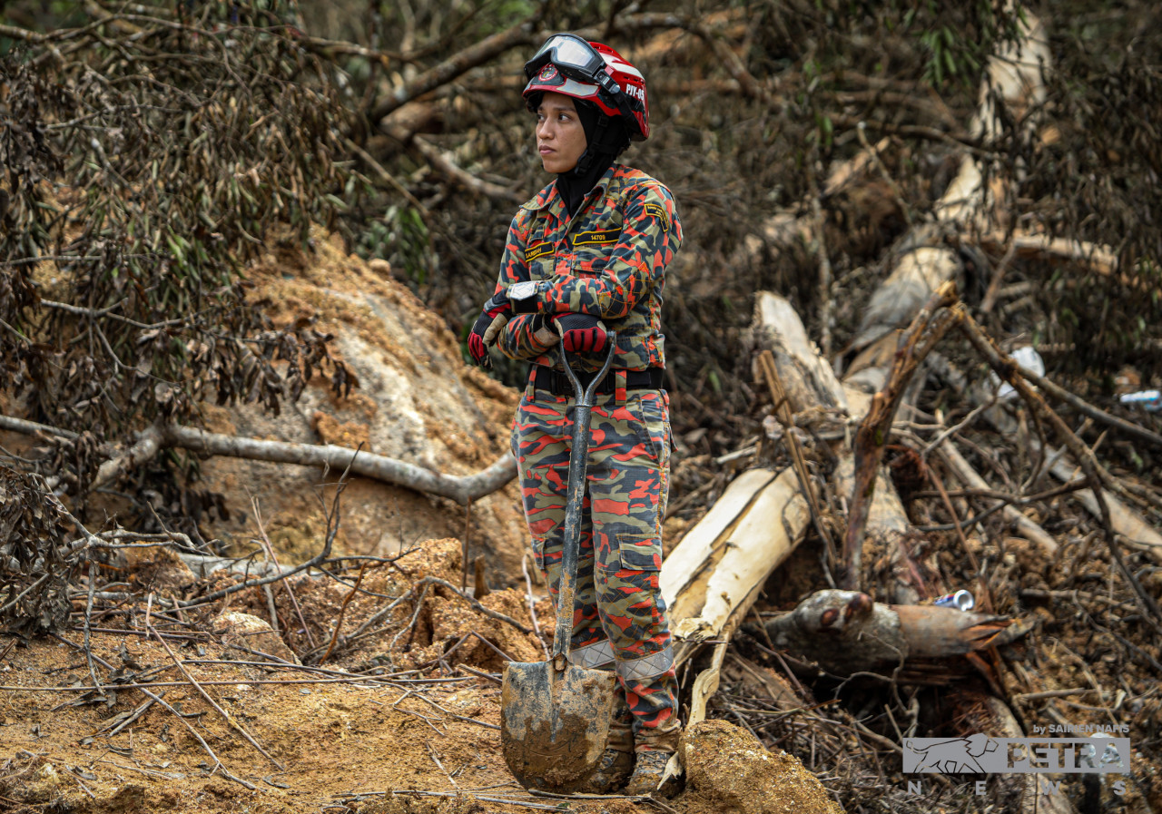 A Fire and Rescue officer holds one of the tools needed to dig through the mud. Rescue workers banded together, regardless of age or gender, in an exhausting mission to comb through the landslide tragedy site at Father’s Organic Farm. – SAIRIEN NAFIS/The Vibes pic, December 25, 2022